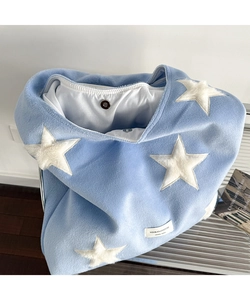 Close-up of blue plush wool tote bag featuring star patches and metal magnetic clasp