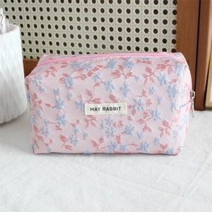 Detail of pink floral jacquard pencil case with MAY RABBIT label and metal zipper closure