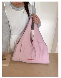 Detail of light pink nylon tote bag with GoodThing lettering and metallic buckle
