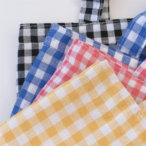 Close-up of gingham pattern fabric texture and neat stitching on colorful tote bags