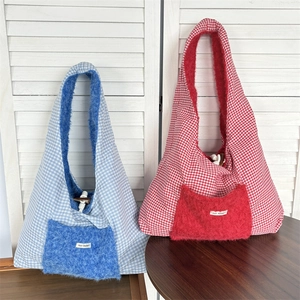 Close-up of winter tote bag with blue and red plaid fabric and plush front pocket detail