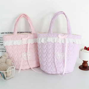 Detail of heart quilted tote bag with lace trim and sweet ribbon bow in soft pastel colors