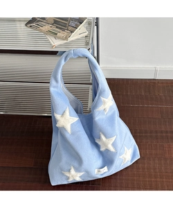 Close-up of light blue plush tote bag featuring five large white furry star appliques