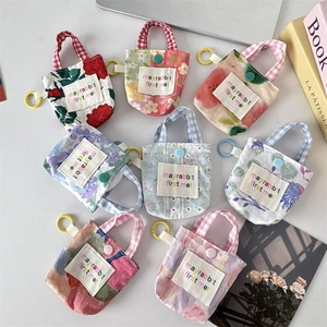 Gros plan sur des mini pochettes de rangement fleuries avec mousquetons colorés