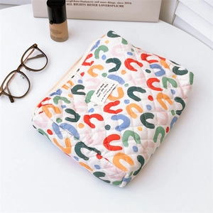 Detailed close-up of quilted floral makeup bag with horseshoe prints and zipper closure