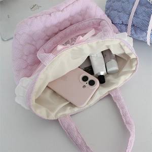 Spacious interior of pink striped quilted tote bag with lace trim and daily essentials
