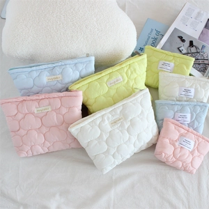 Close-up of quilted heart patterns and pastel colors on large capacity cosmetic bags
