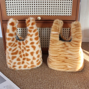 Detail of plush faux fur handbags showing giraffe and tiger patterns with checked lining