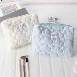 Puffy quilted cloud cosmetic bags in off-white and light blue with metal zippers