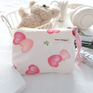 Detailed macro view of small canvas coin purse with pink hearts and May Rabbit label
