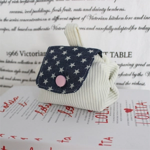 Detailed view of mini corduroy coin purse with star pattern denim flap and pink button
