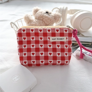Detailed view of red and white checkered pouch with heart patterns and soft rope zipper pull