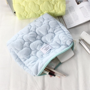 Detailed view of quilted heart pattern on soft candy-colored makeup storage bag