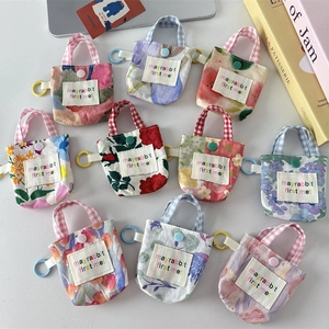 Détail de mini étuis à écouteurs en patchwork floral avec crochets et patchs brodés