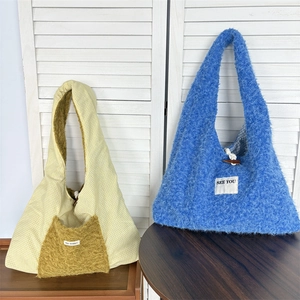 Detailed view of large winter tote bags with plaid fabric, blue faux fur and duffle button
