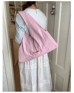 Pink quilted tote bag with GoodThing embroidery worn by a model in a minimal setting