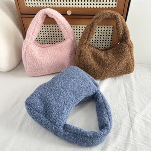 Detailed view of three plush faux fur hobo bags in pink, brown and grey blue with zippers
