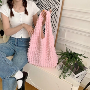 Detail of pink bubble texture tote bag showing 3D popcorn pattern and soft strap