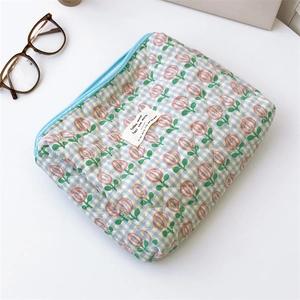 Detailed macro view of quilted tulip pattern fabric and sky blue zipper on storage bag