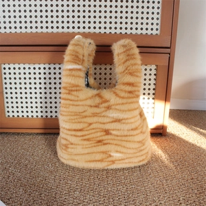 Detail of plush orange tabby cat pattern handbag with classic black and white checkered lining