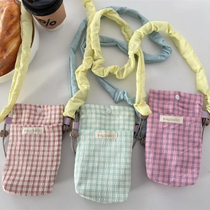 Three minimalist plaid crossbody phone bags with ruffled straps in pastel colors