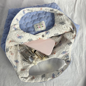 Detail of the quilted tote bag showing inner elephant print and magnetic closure