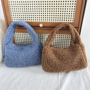 Detailed close-up of fluffy plush handbags in blue and brown showing soft fuzzy texture
