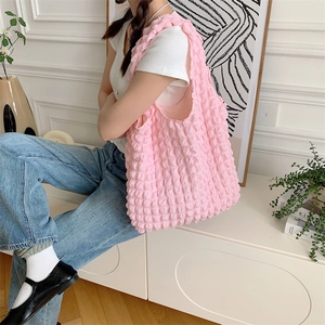 Detail of pink bubble texture tote bag with wide strap and minimalist floral pattern