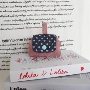 Detail of pink corduroy mini pouch with blue star pattern flap and button closure