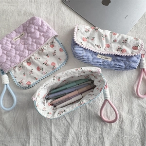 Detail of floral pencil cases with woven rope handles and magnetic snap button closures