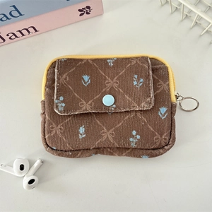 Macro view of floral corduroy coin purse with yellow zipper and front snap pocket