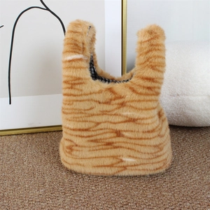 Detail of plush faux fur handbag with orange tiger stripes and black checkered lining