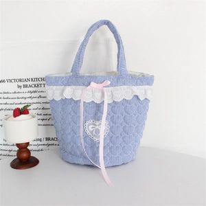 Detail of blue striped quilted tote bag with white heart lace and pink silk ribbon bow