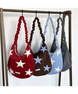 Detail of wool shoulder bags with star patches and gathered straps in four colors