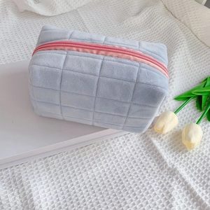 Quilted blue velvet makeup bag with pink zipper and soft macaron color aesthetic