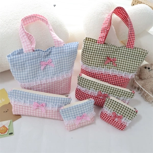 Detailed view of lace trim and bow on checkered fabric bags for daily storage