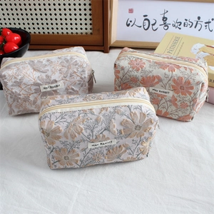 Close-up of jacquard floral pencil cases in pink, purple and beige with metal zipper