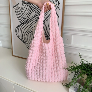 Detail shot of pink popcorn textured fabric shoulder bag with unique bubble pattern