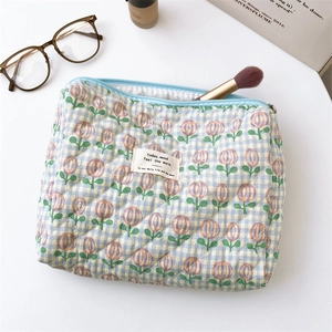 Detailed macro view of floral quilted cotton makeup bag with zip and woven label