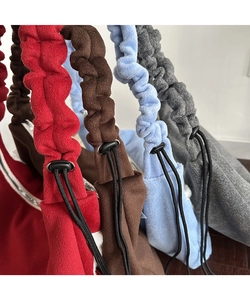 Detail of wool fabric tote bags in four colors with adjustable pleated shoulder straps