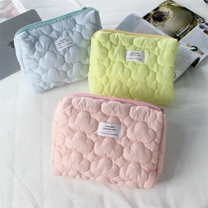 Close-up of quilted cloud texture storage bags in light blue, yellow and pink colors