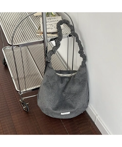 Detail of dark grey felt tote bag featuring star embossing and ruffled cloud strap