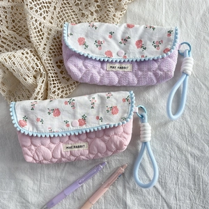 Detail of floral pencil cases with heart quilting and blue pompom lace trim