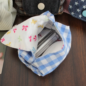 Internal view of blue plaid mini pouch with floral lining holding lipstick and small items