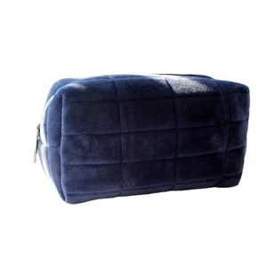 Navy blue velvet makeup pouch with grid pattern embossing and gold zipper closure
