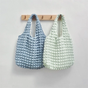 Detail showing bubble texture tote bags in blue and green with pleated 3D popcorn fabric