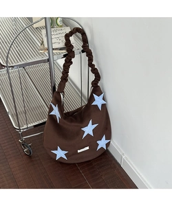 Close-up of brown wool tote bag with star patches and stylish scrunchie shoulder strap