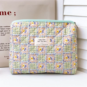 Close-up of quilted floral storage bag with mint green zipper and fabric label