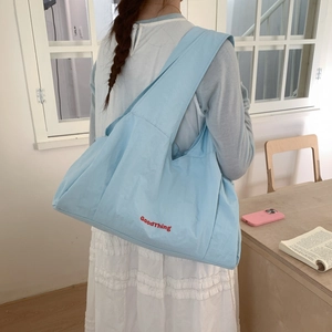 Sky blue plaid tote bag with GoodThing embroidery worn with a white dress