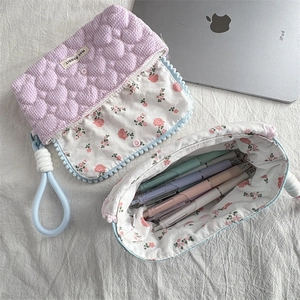 Macro view of quilted floral pencil case with soft cotton handles and stylish fabric texture